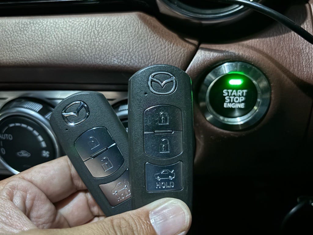 登録が完了したロードスターのスマートキー2個をスタートボタンの前で持っている