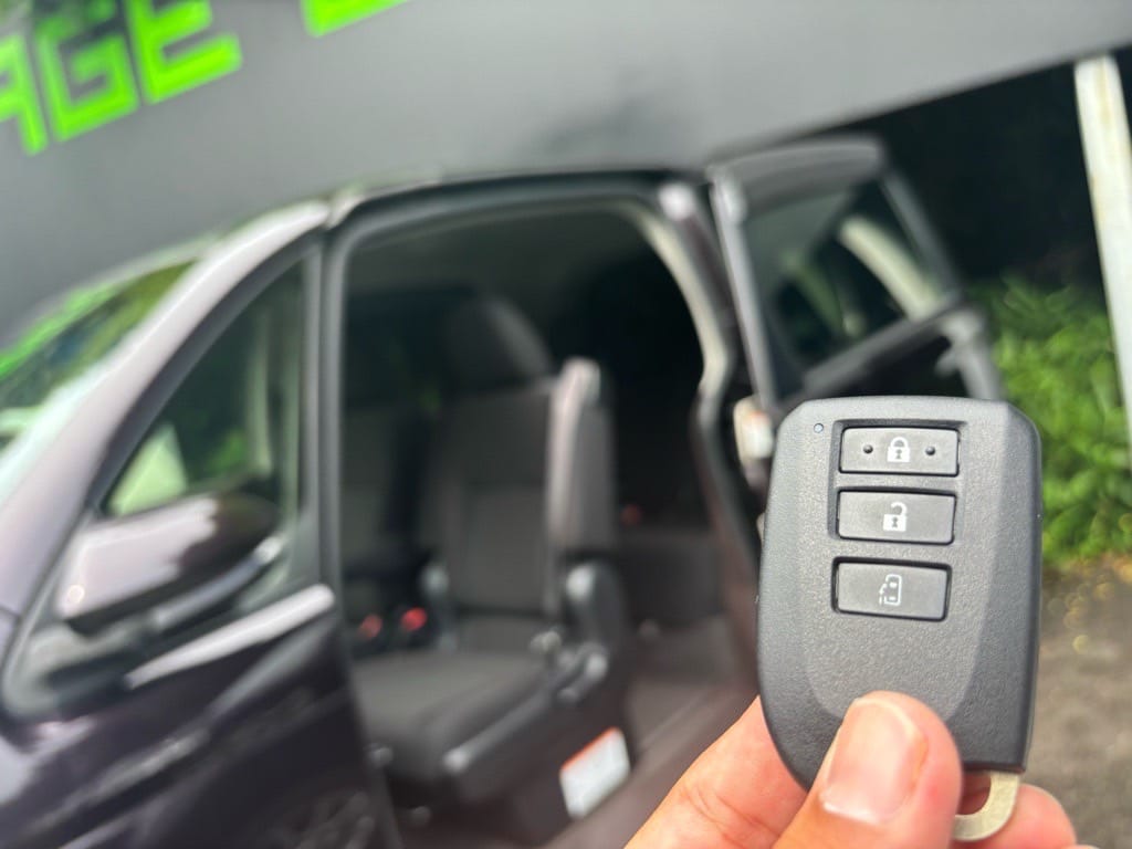 スライドドアが開いたスペイドの前でスマートキーを持っている