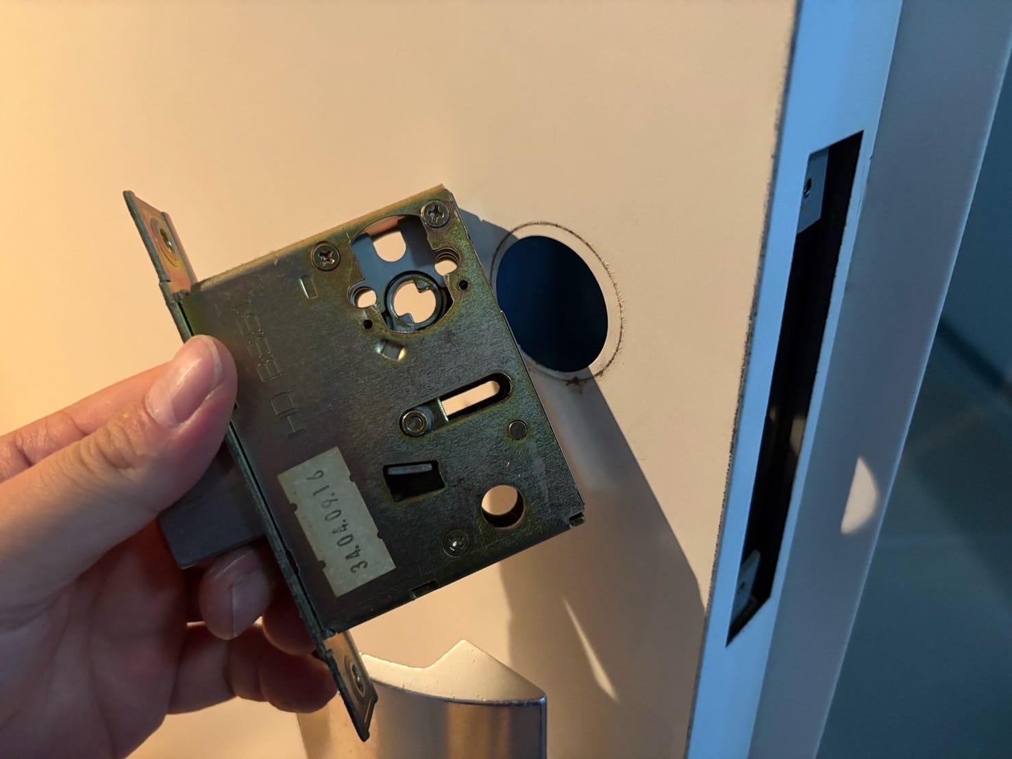 取り外したケースロックを手に持っている