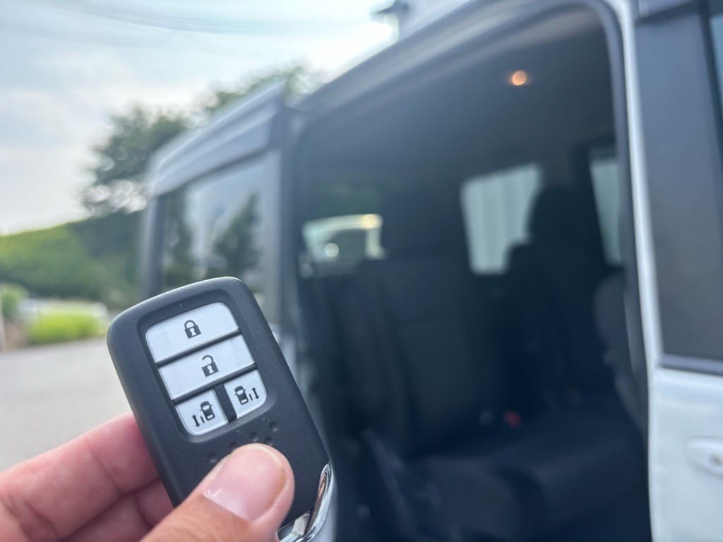 ステップワゴンのリアエンブレムの前で、スマートキー2本を手に持って撮影した完了記念の写真