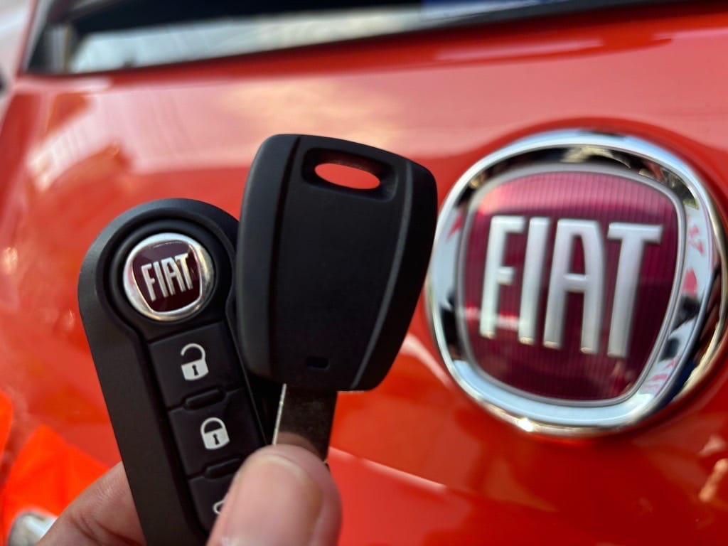 フィアットの既存のリモコンキーと今回作製したスペアキーを手に持っている