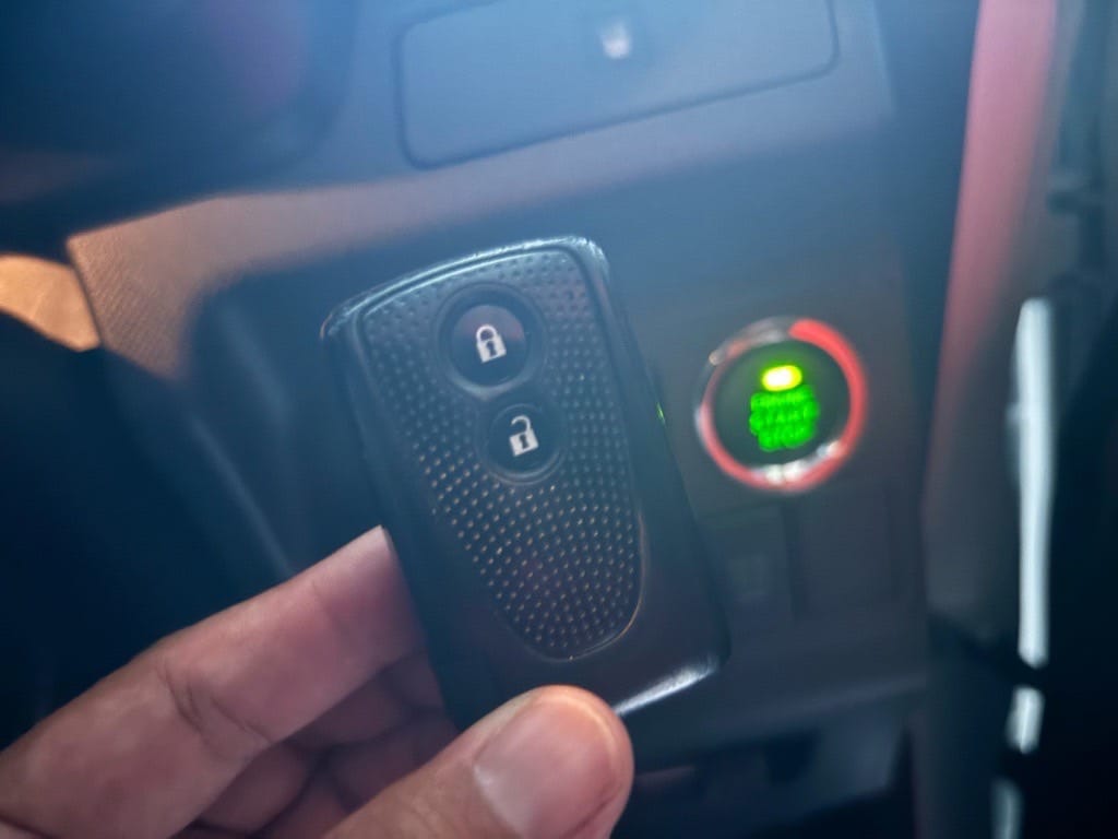 登録が完了したムーヴのキーフリーリモコンをスタートボタンの前で持っている