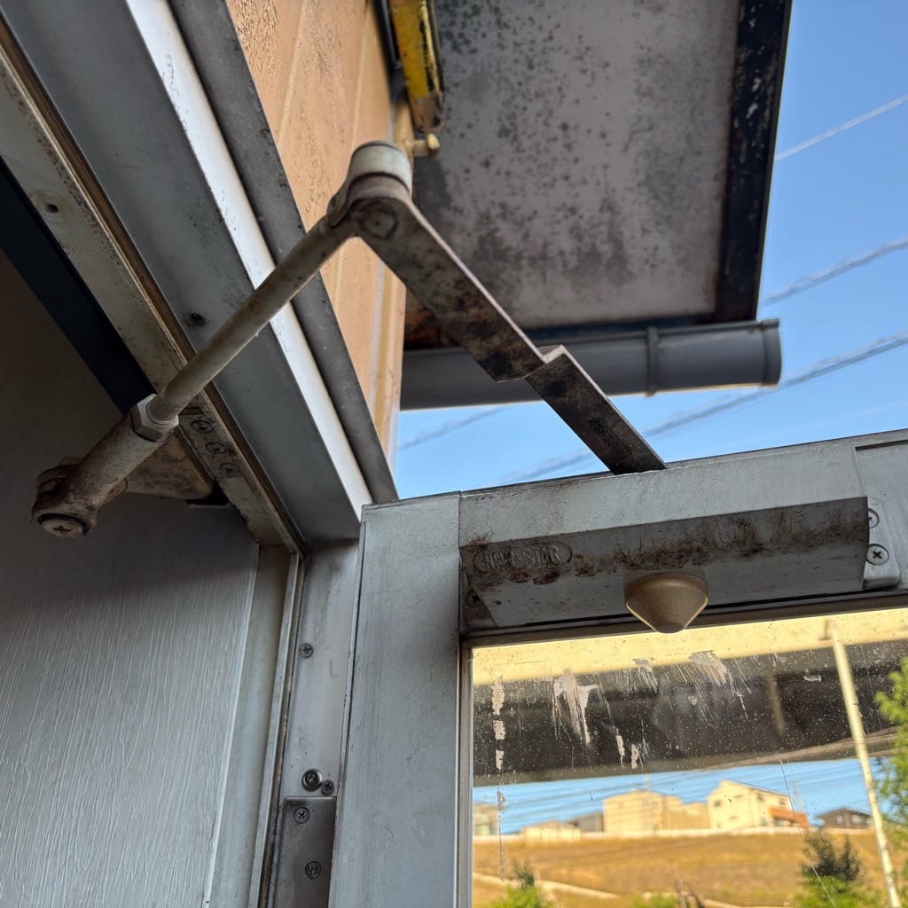 古くなったドアシリンダーがついた店舗入り口ドア