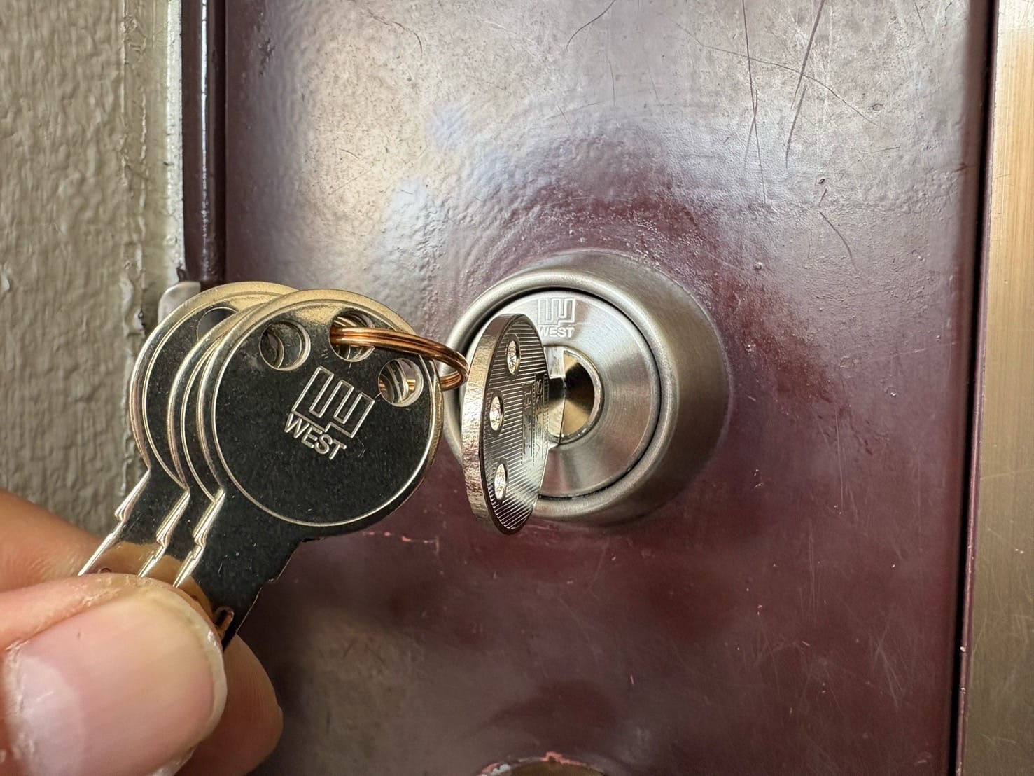 ディンプルシリンダーへ交換。付属の鍵数本を扉についたシリンダーの近くで持っている