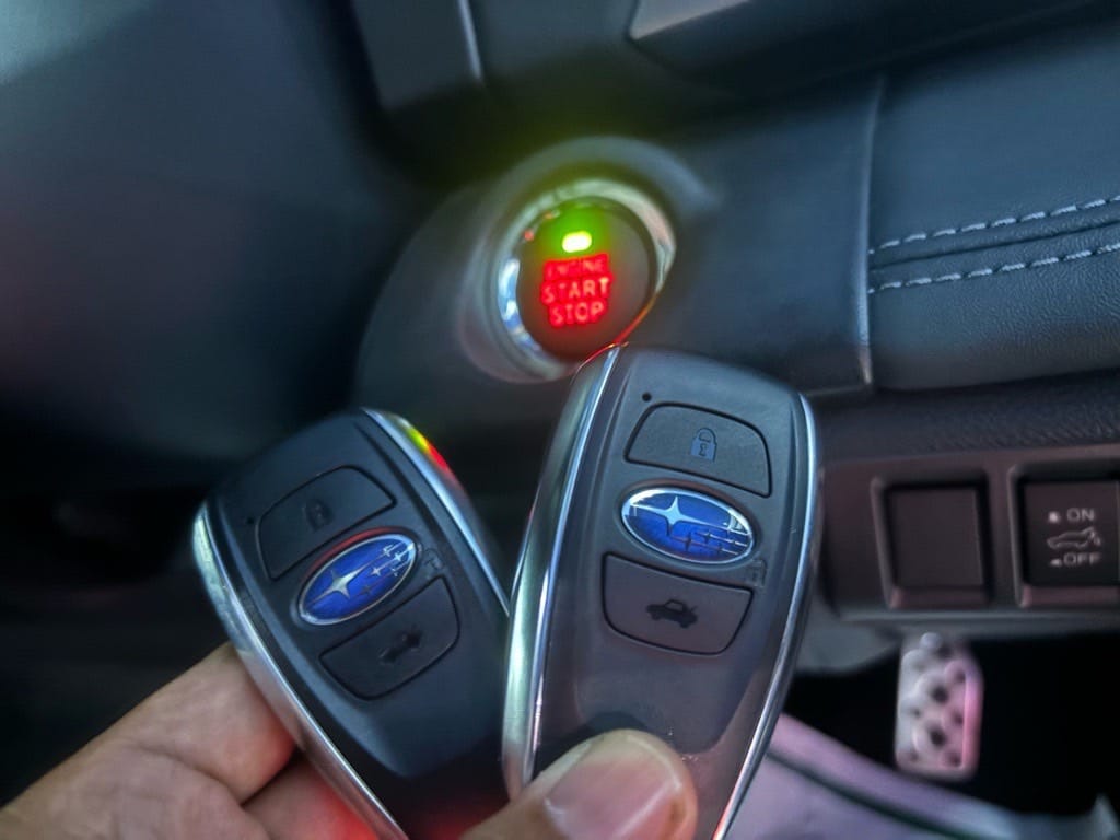 登録が完了したアウトバックのスマートキーをスタートボタンの前で持っている