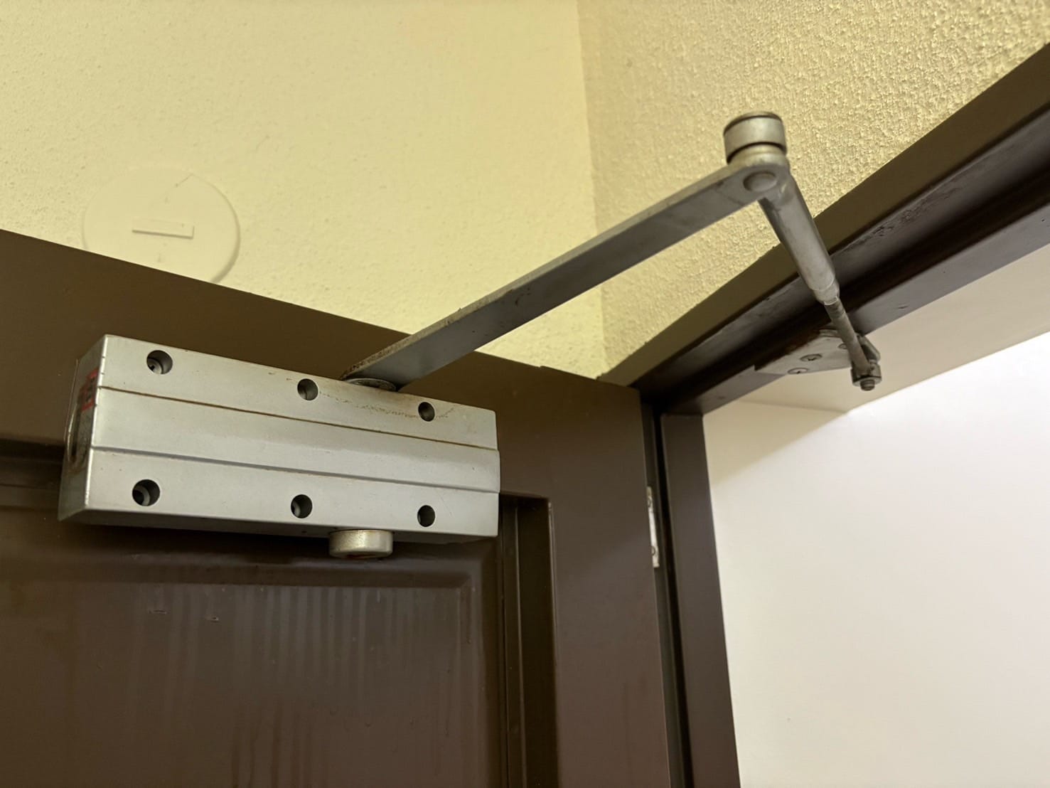 油漏れがおきているドアクローザーが玄関ドアについている