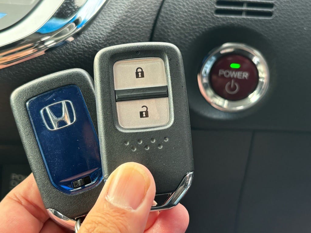 登録が完了したジェイドのスマートキーをスタートボタンの前で持っている