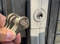 交換完了。付属の鍵数本をドアの近くで持っている