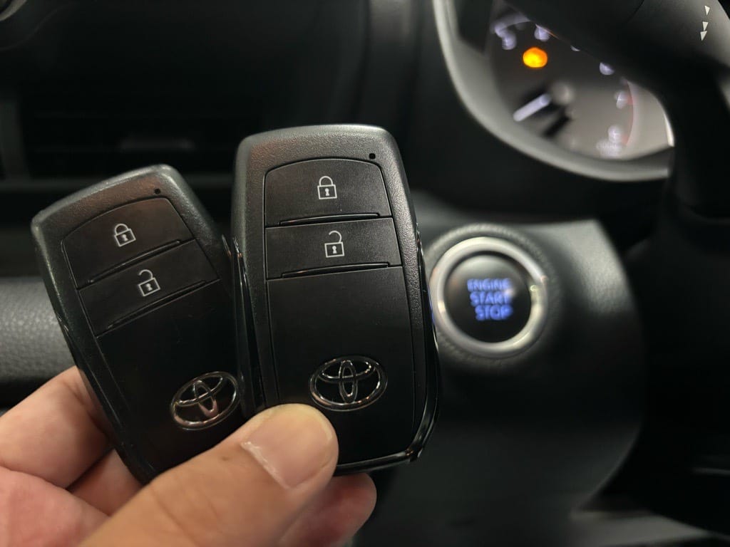 スマートキー登録が完了。ヤリスのスタートボタンの近くでスマートキーを持っている