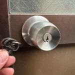 鍵交換完了。ドアノブの近くで鍵数本を持っている