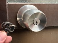 鍵交換完了。ドアノブの近くで鍵数本を持っている