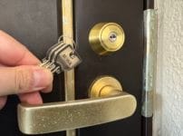 鍵交換完了。扉のシリンダー近くで付属の鍵を持っている