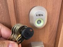 鍵交換完了。鍵穴の近くで付属の鍵を持っている